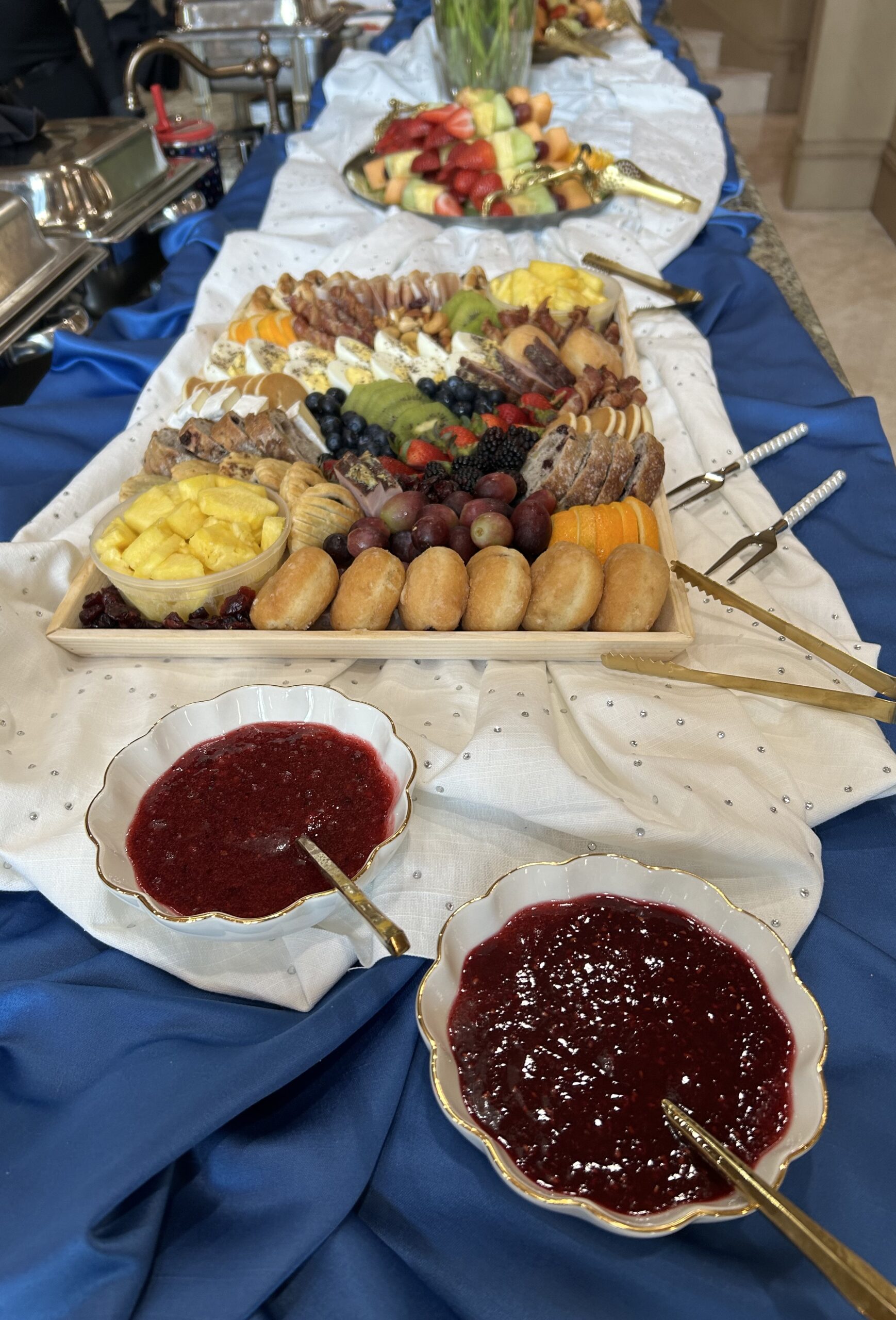 Wide view of a catering table with grazing board and fruit platters