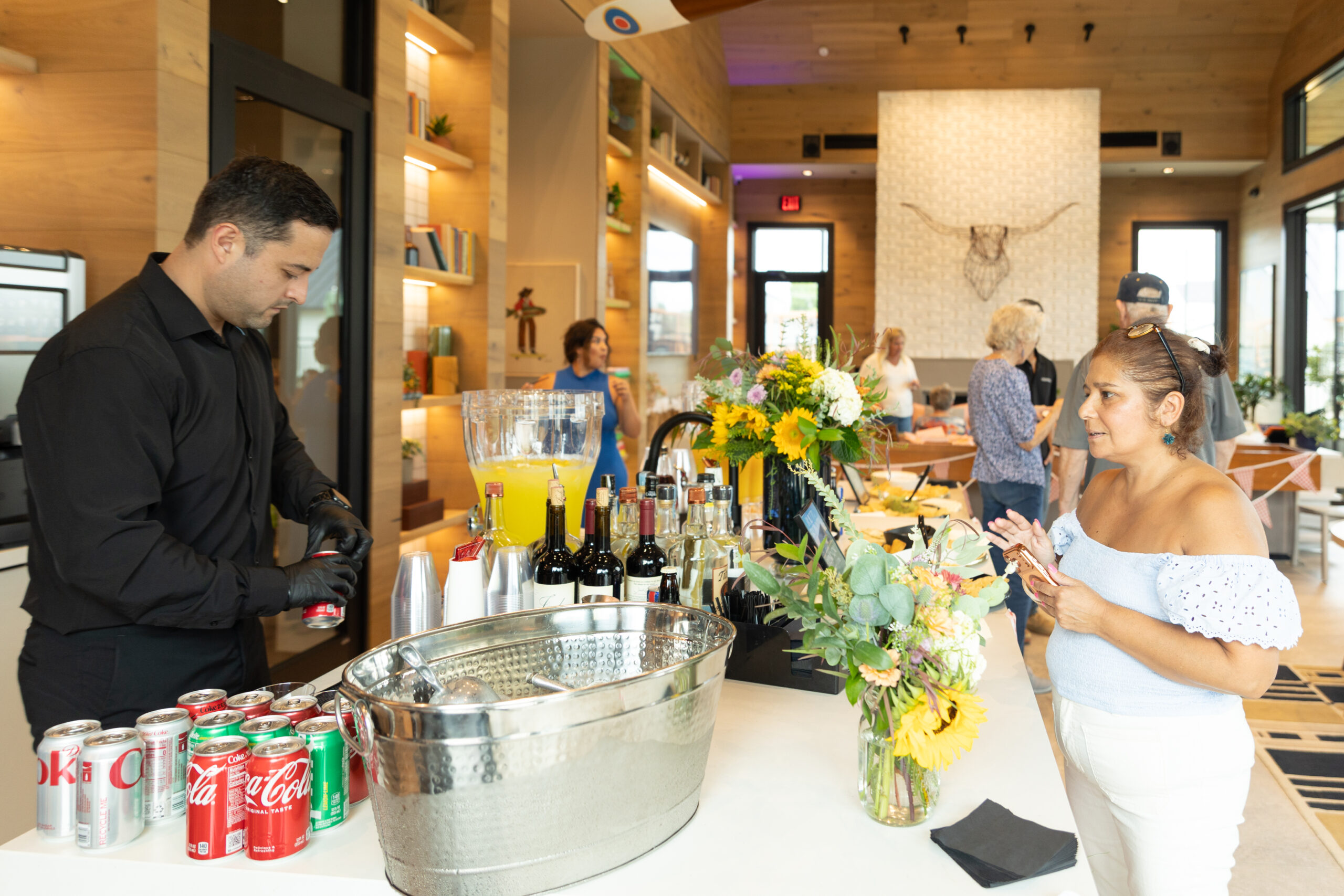 Bartender serving drinks at a community grand opening event